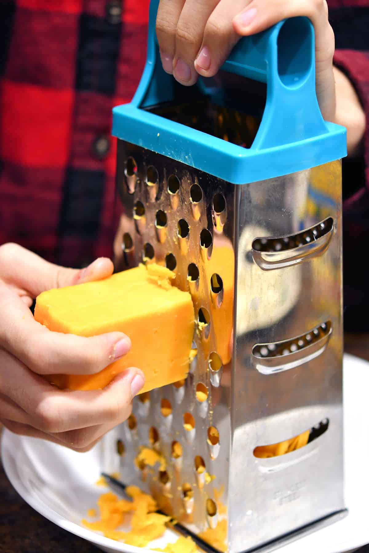shredding cheddar cheese with a box grater