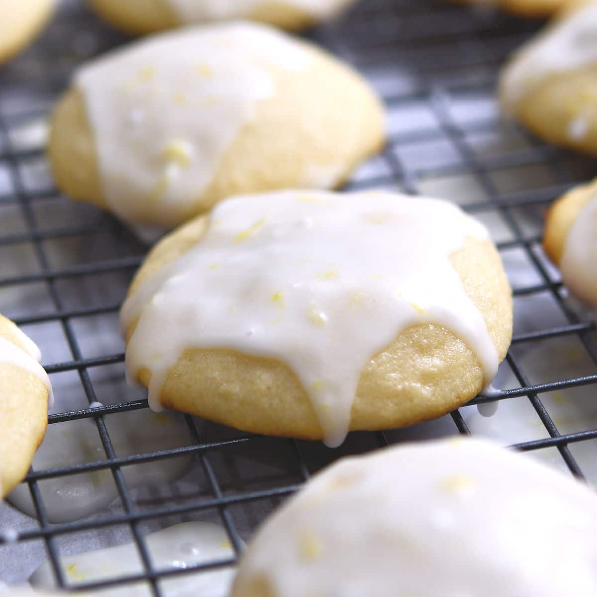 closeup of lemon ricotta cookies with sweet lemon glaze spooned overtop