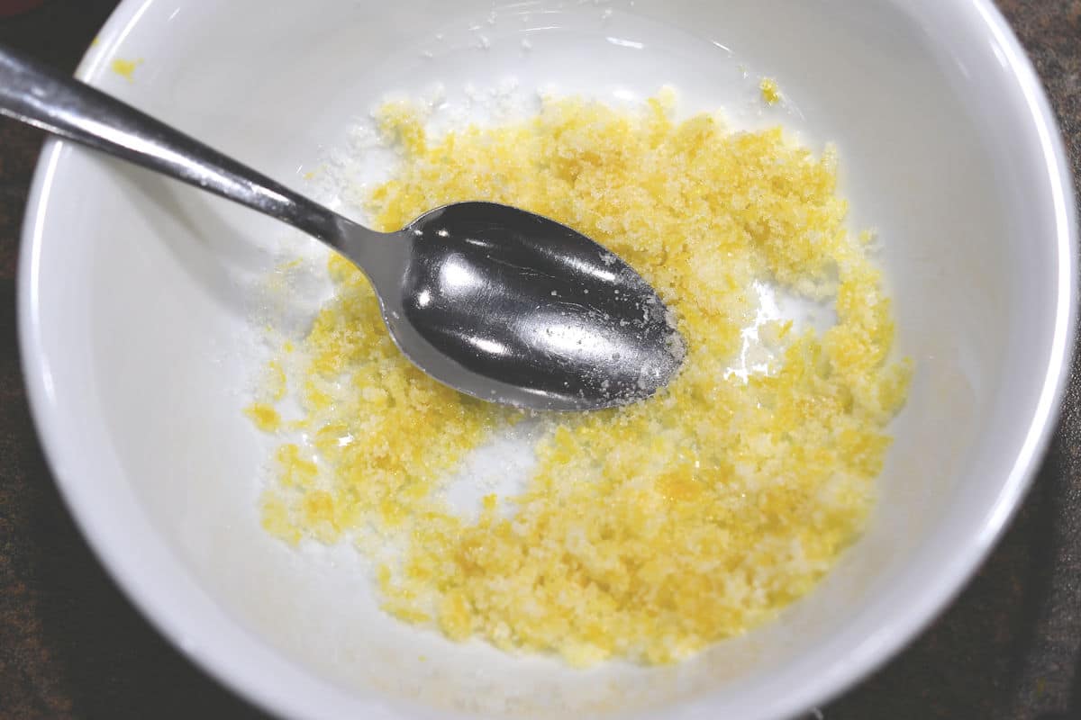 closeup of mixing lemon zest with sugar to help incorporate it in cookie dough