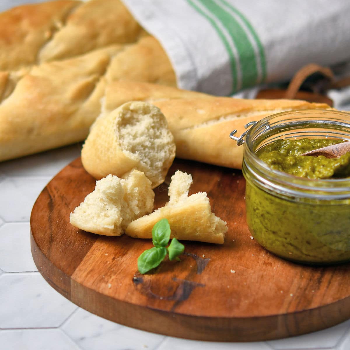 broken chunks of baguette with pesto