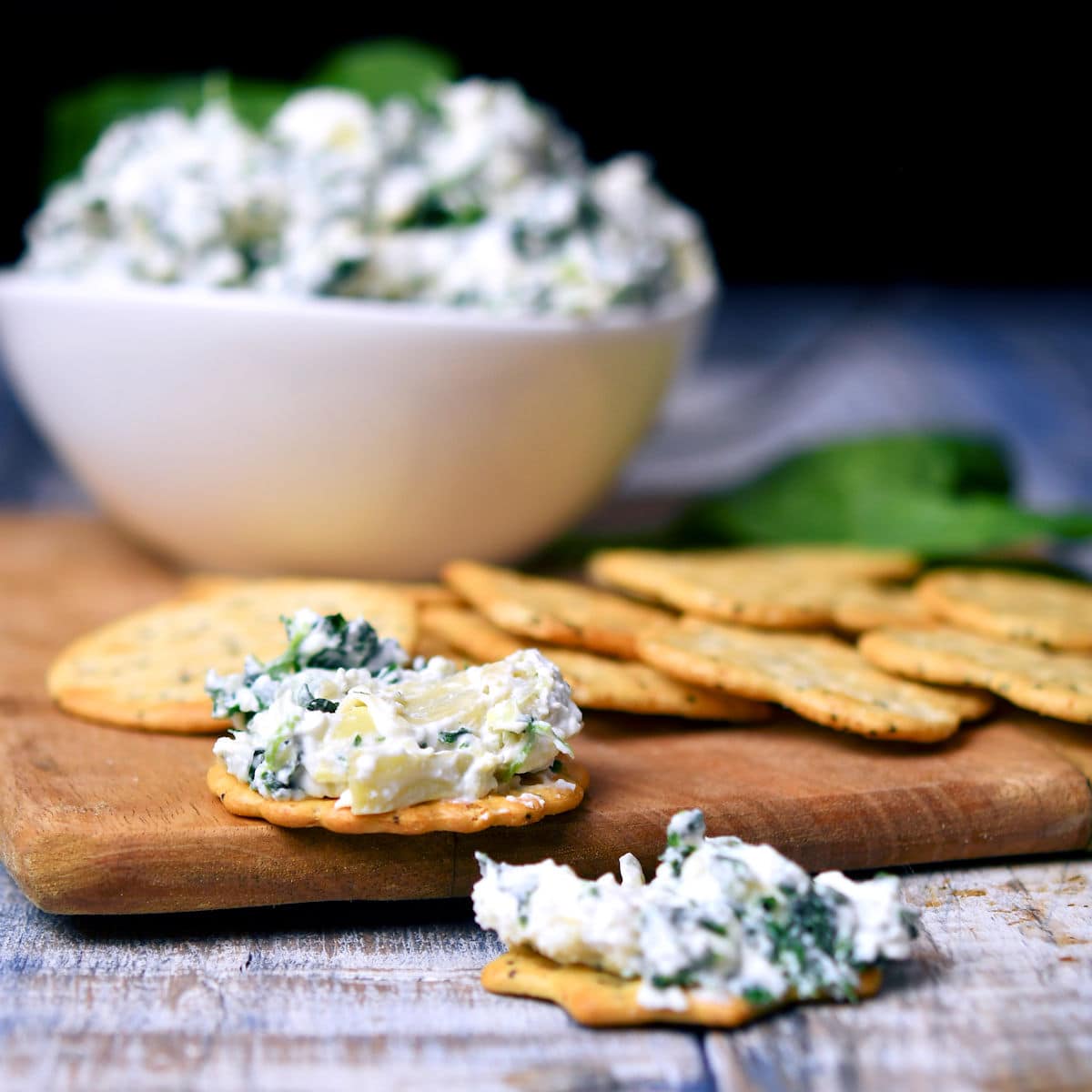 closeup of savory cracker with cold spinach artichoke dip