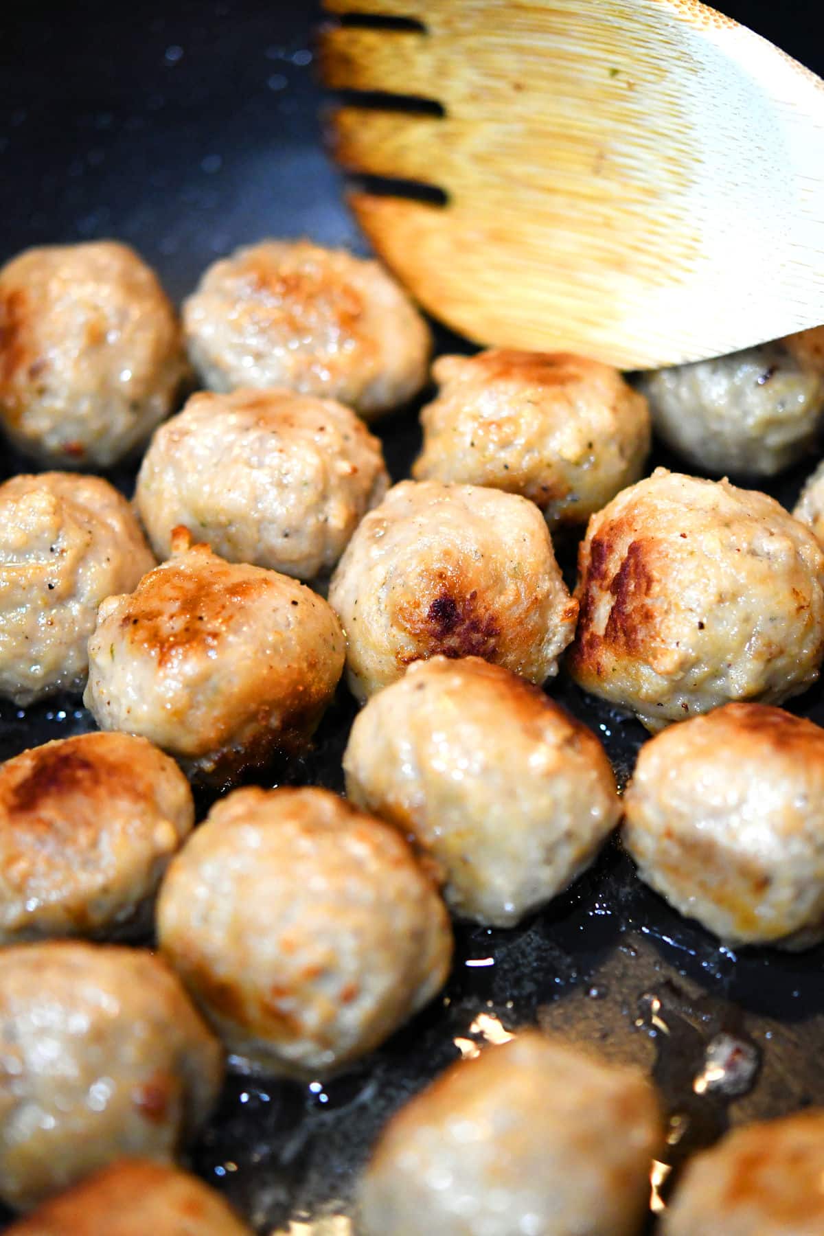 closeup of meatballs in a skillet with a little bit of sear