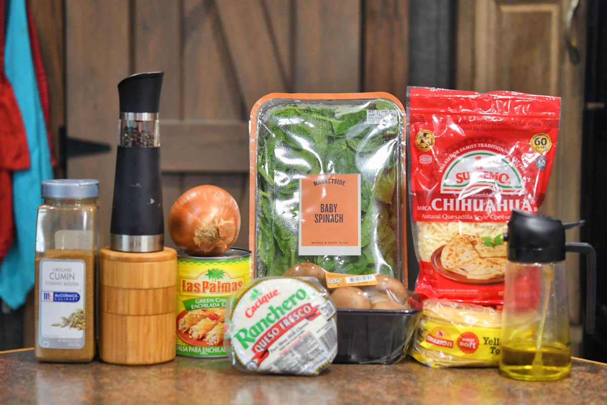 ingredients for vegetable enchiladas on a brown kitchen countertop