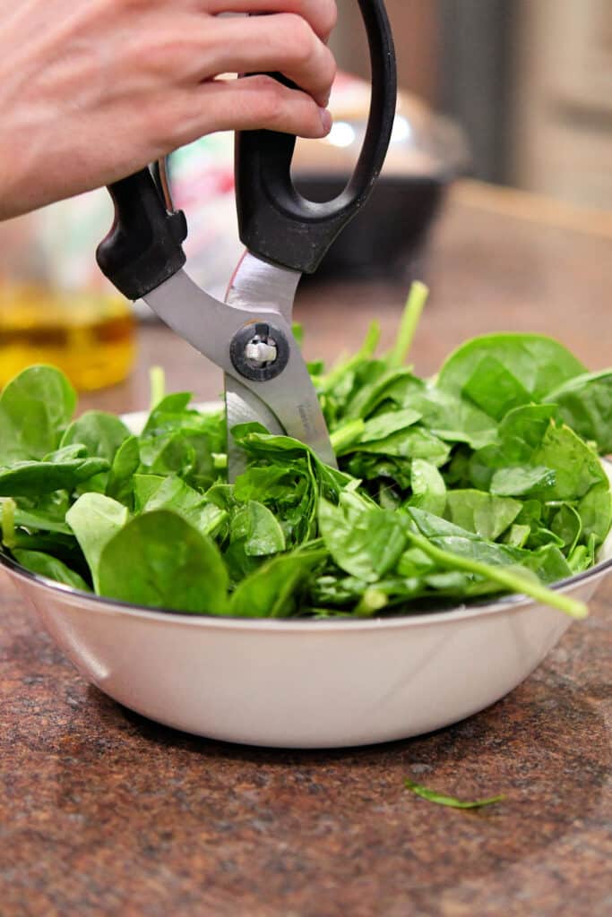 prepping the baby spinach leaves with kitchen shears to save time.