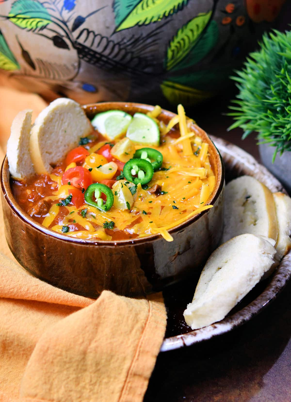 steak chili in a brown drip bowl with toasted bread slices