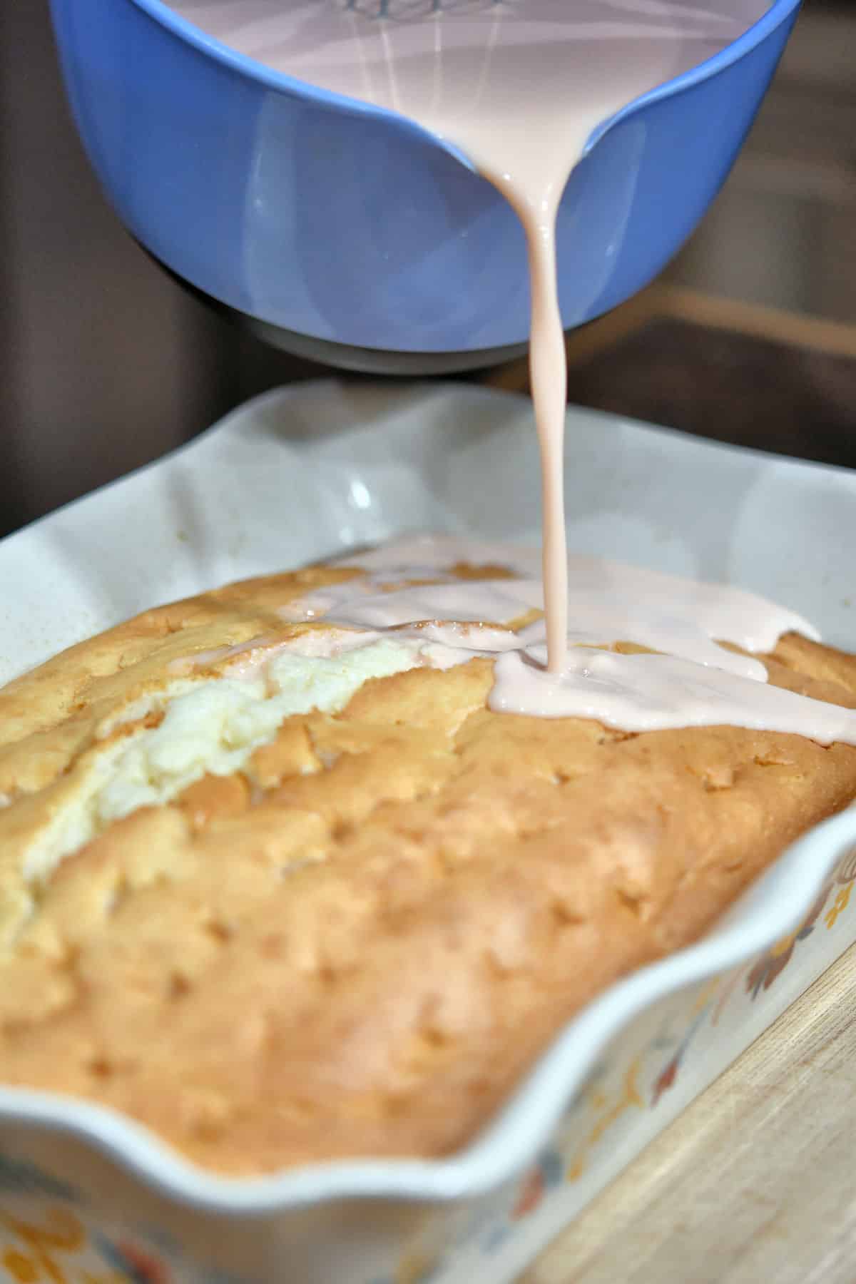 pouring a milk mixture on top of a tres leches cake