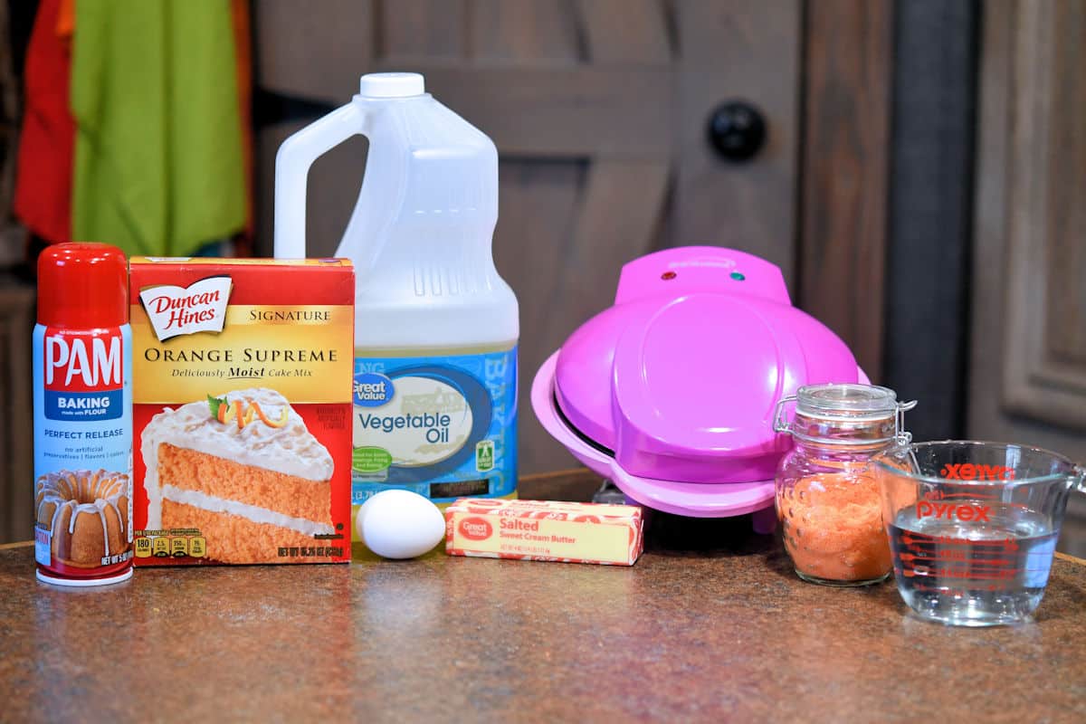 ingredients of orange donuts on countertop.
