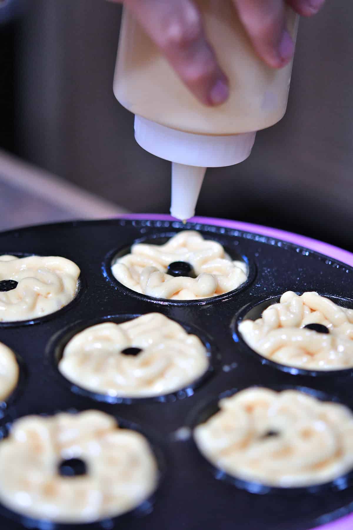 closeup of filling brentwood donut maker with batter.