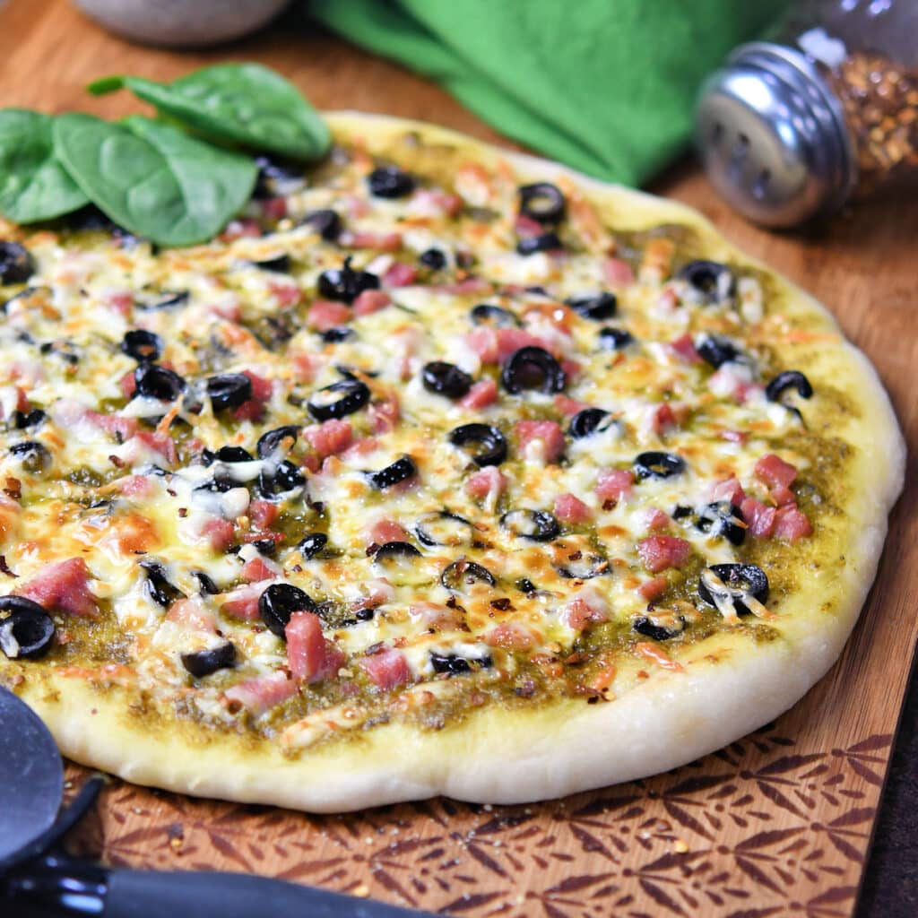 Gourmet Pesto Pizza With Ham and Black Olives