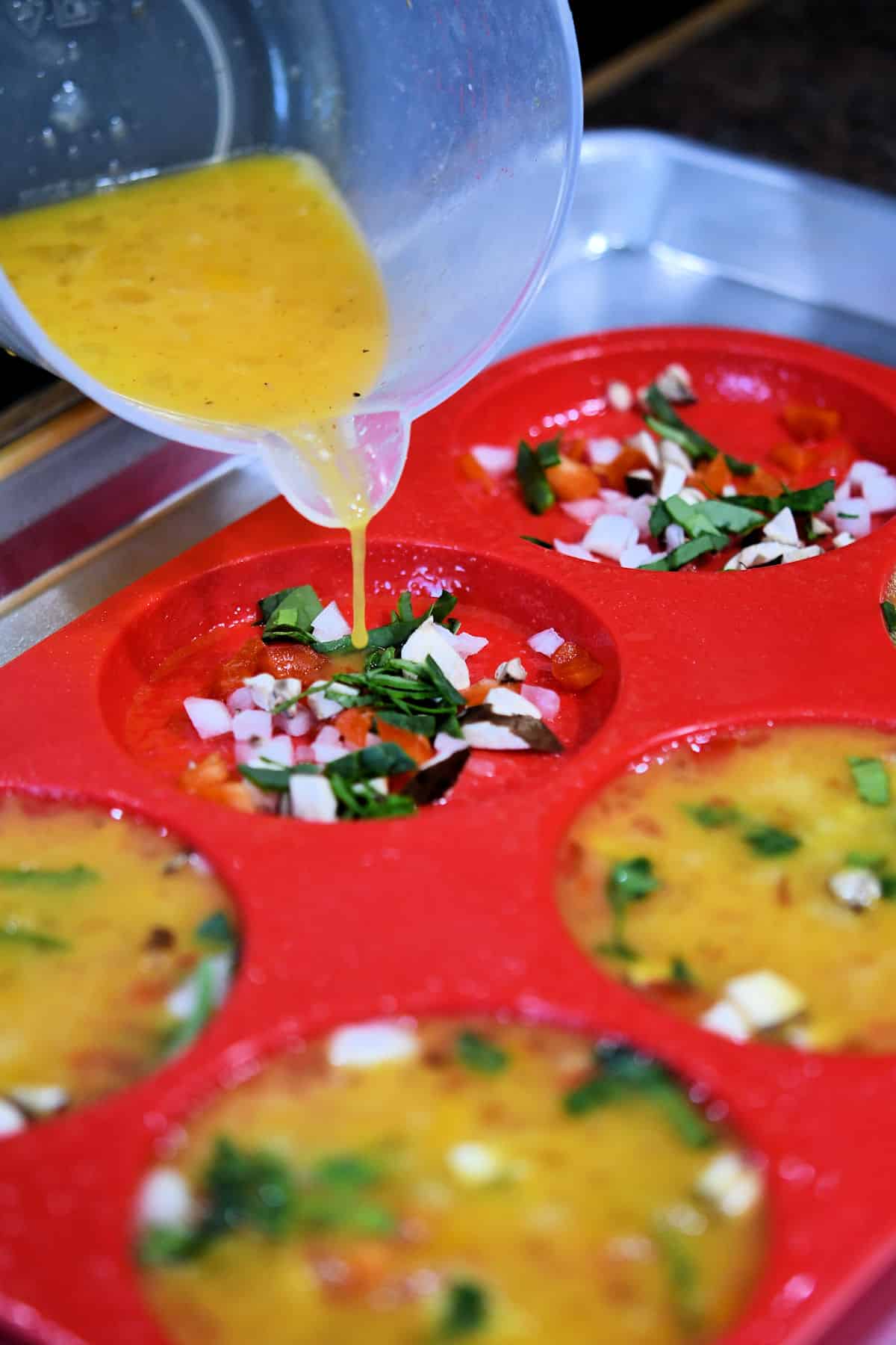 pouring the egg mixture into the egg patty molds
