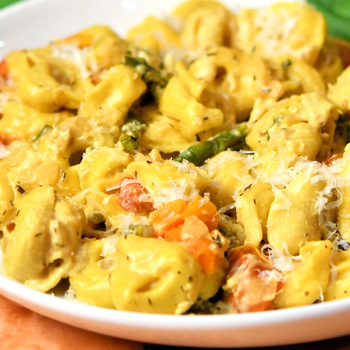 Cheesy Asparagus Tortellini on a white ceramic plate