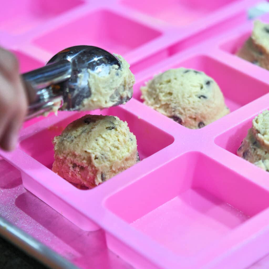 using a cookie scoop to portion out cookie dough into brownie mold